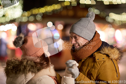 Image of happy couple holding hands at christmas market