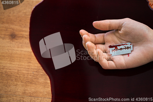 Image of dead woman hand in blood on floor at crime scene