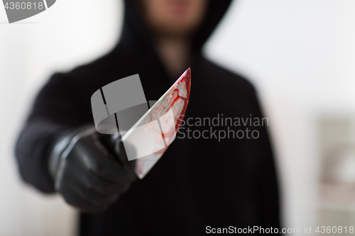 Image of close up of criminal with blood on knife