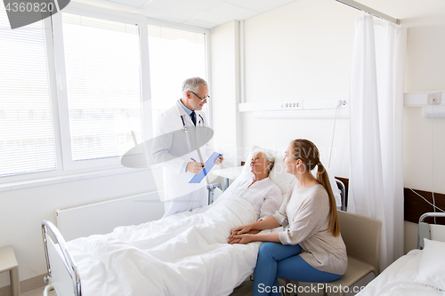 Image of senior woman and doctor with clipboard at hospital