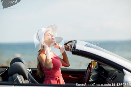 Image of happy young woman in convertible car