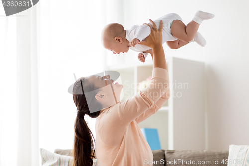 Image of happy mother playing with little baby boy at home