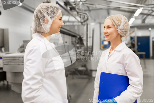 Image of happy women technologists at ice cream factory