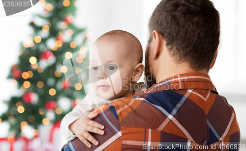 Image of close up of happy baby with father at christmas