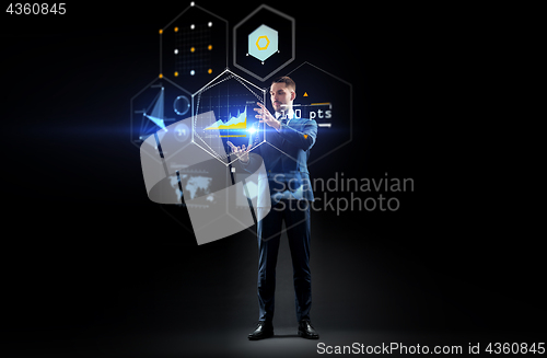 Image of businessman working with charts on virtual screen