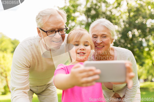 Image of senior grandparents and granddaughter selfie