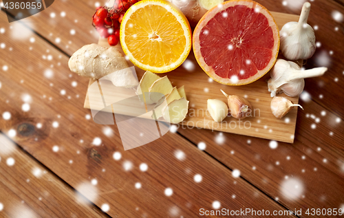 Image of citrus, ginger, garlic and rowanberry on wood