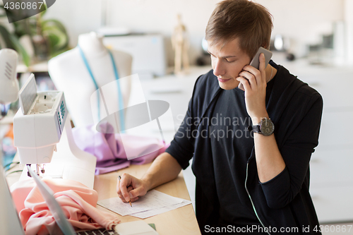 Image of fashion designer calling on smartphone at studio