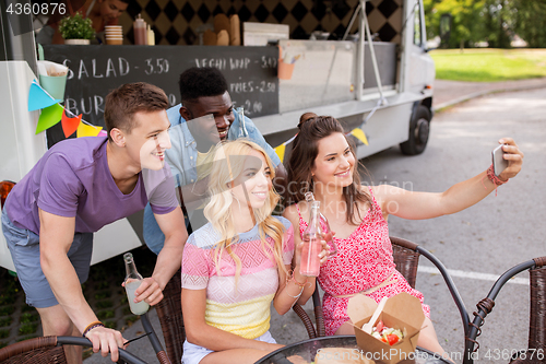 Image of happy young friends taking selfie at food truck