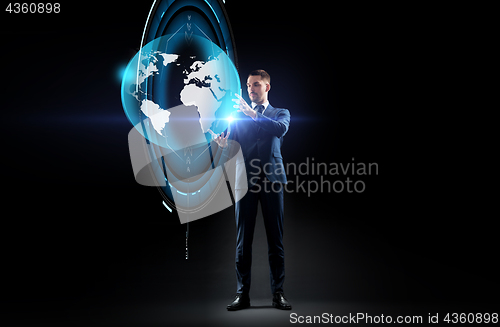 Image of businessman with earth hologram over black