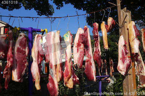 Image of The suspended pieces of the meat drying outside