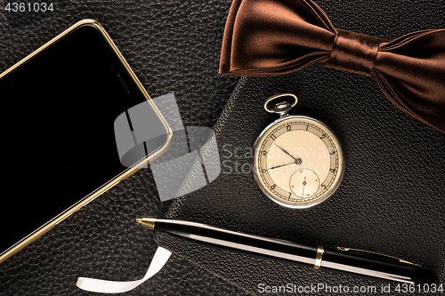 Image of Men&#39;s accessories are watch, pen, phone and bow-tie