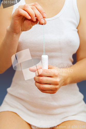 Image of tampon in hands of woman 