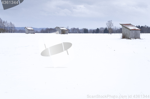 Image of a snow covered landscape with three huts