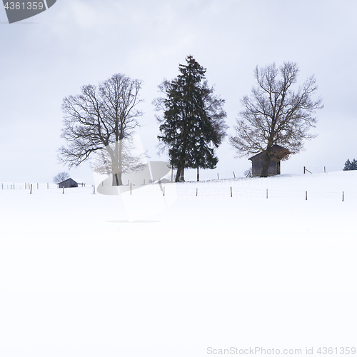 Image of a snow covered landscape with three huts