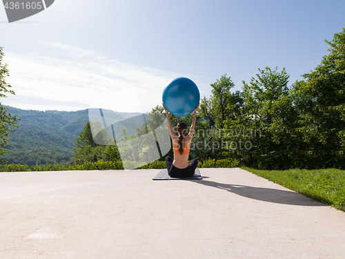 Image of woman doing exercise with pilates ball