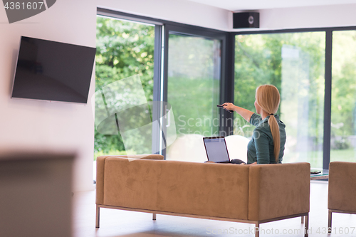 Image of Young woman using laptop at home