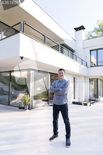 Image of man in front of his luxury home villa