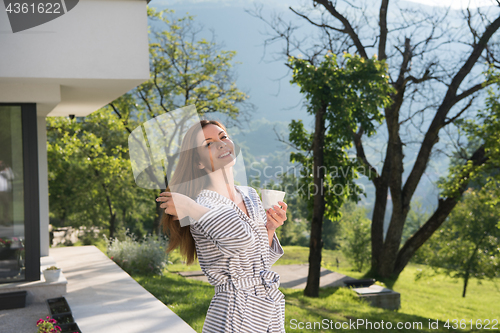 Image of woman in a bathrobe enjoying morning coffee