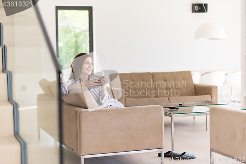 Image of young woman in a bathrobe enjoying morning coffee