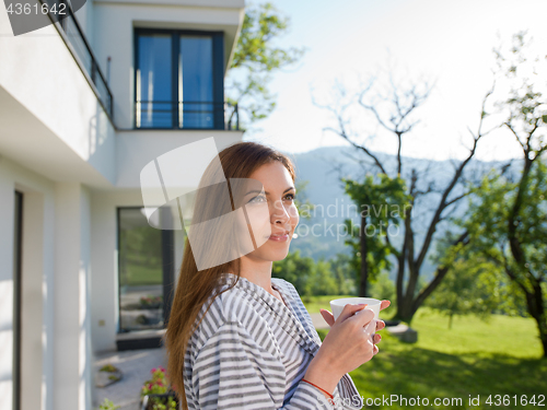 Image of woman in a bathrobe enjoying morning coffee