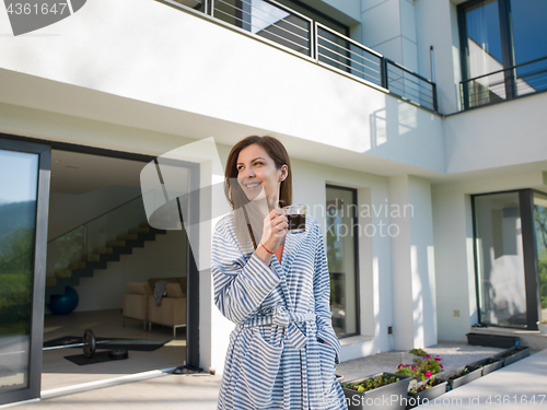 Image of woman in a bathrobe enjoying morning coffee