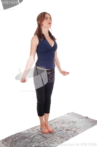 Image of Slim woman standing doing yoga