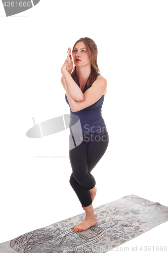Image of Woman standing on one leg and arms twisted