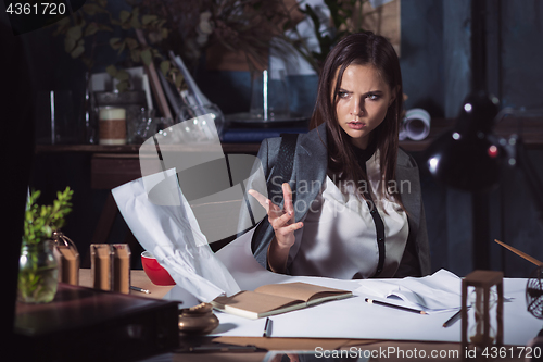 Image of Young business woman throwing documents at camera.