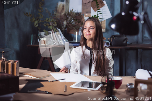 Image of Young frustrated woman working at office desk in front of laptop