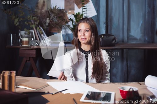 Image of Young frustrated woman working at office desk in front of laptop