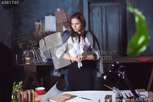 Image of Young business woman throwing documents at camera.