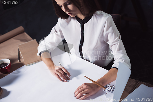 Image of Architect working on drawing table in office