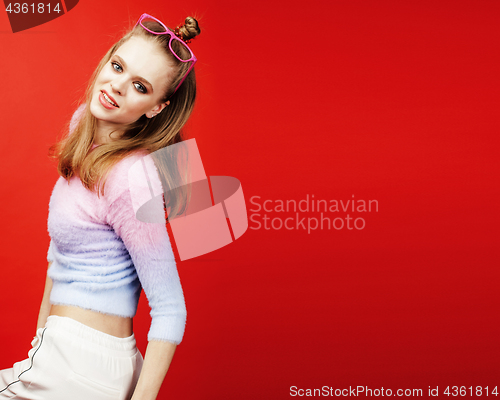 Image of young pretty teenage girl on bright red background, happy smilin