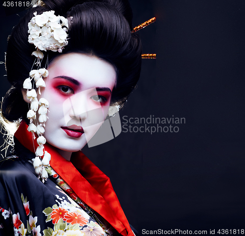 Image of young pretty geisha in kimono with sakura and decoration