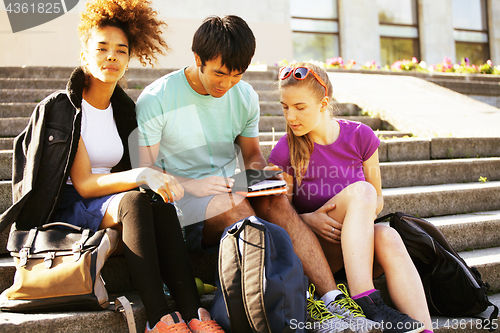 Image of cute group of teenages at the building of university with books huggings, diversity nations