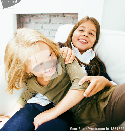 Image of two cute sisters at home playing