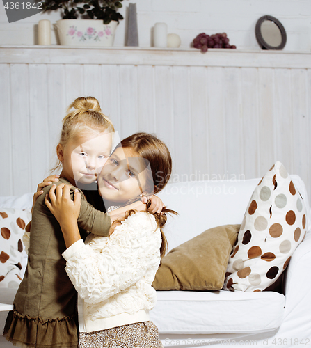 Image of two cute sisters at home playing