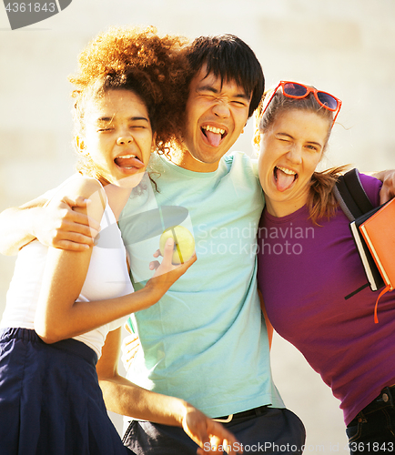 Image of cute group of teenages at the building of university with books 