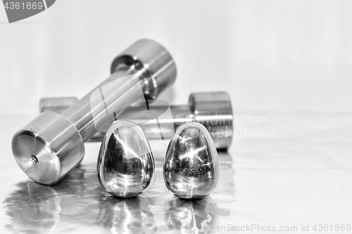 Image of Metal dumbbells and steel eggs, the concept of sports training and the achievement of muscle strength