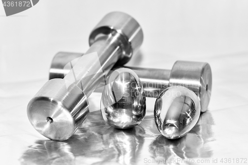 Image of Metal dumbbells and steel eggs, the concept of sports training and the achievement of muscle strength