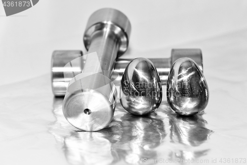 Image of Metal dumbbells and steel eggs, the concept of sports training and the achievement of muscle strength