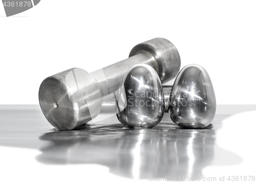 Image of Metal dumbbells and steel eggs, the concept of sports training and the achievement of muscle strength