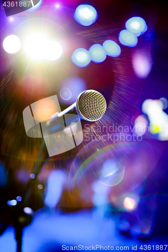 Image of Microphone on stage against a background of auditorium.