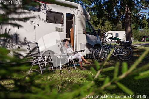 Image of Woman resting near motorhomes in nature. Family vacation travel,