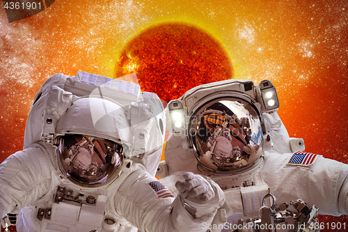 Image of Spacecraft and astronauts in space on background sun star