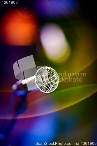 Image of Microphone on stage against a background of auditorium.