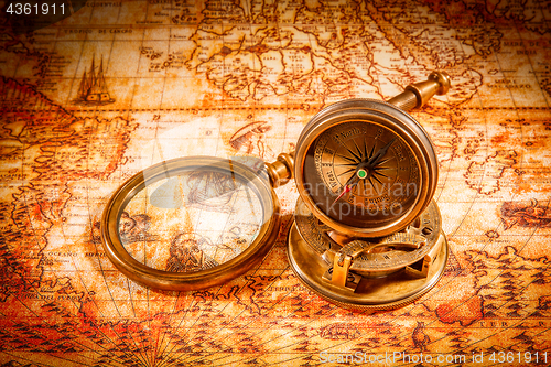 Image of Vintage compass lies on an ancient world map.