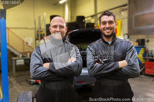 Image of auto mechanics or tire changers at car shop