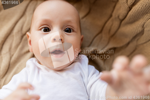 Image of close up of sweet little baby boy lying on blanket